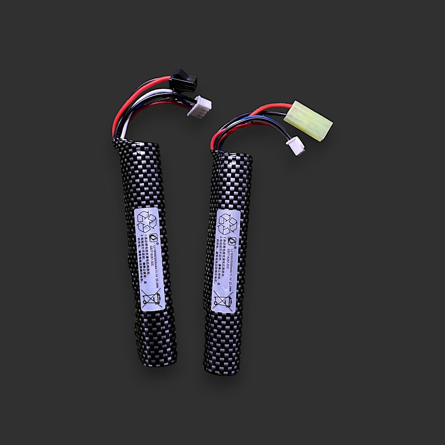 Two BlasterMaster 11.1V 18350 2000mAh Tamiya 30C long skin batteries with black and white checkered coverings and various colored wires and connectors lie on a dark background, offering high-efficiency power ideal for gel blaster enthusiasts.