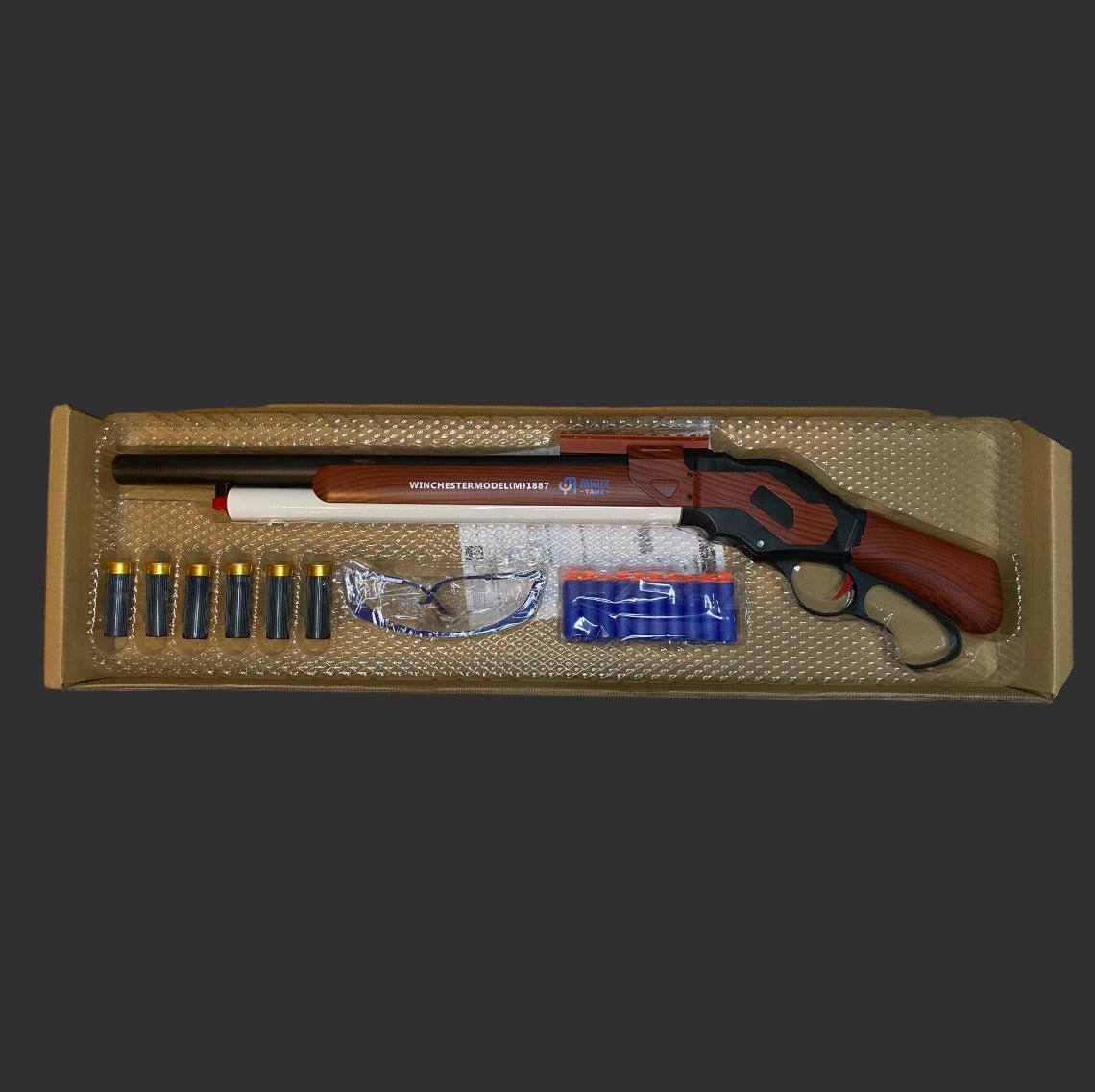 A boxed set featuring the BlasterMasters M1887 Foam Shell | Shotgun with ammunition cartridges, safety glasses, and additional accessories.