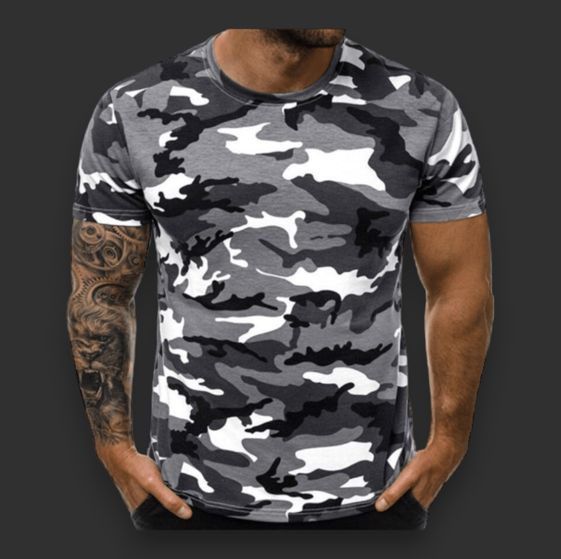 Man wearing a black and white camouflage-patterned Camo T-Shirt from BlasterMaster, with visible tattoo sleeve on his left arm, standing against a plain dark background.