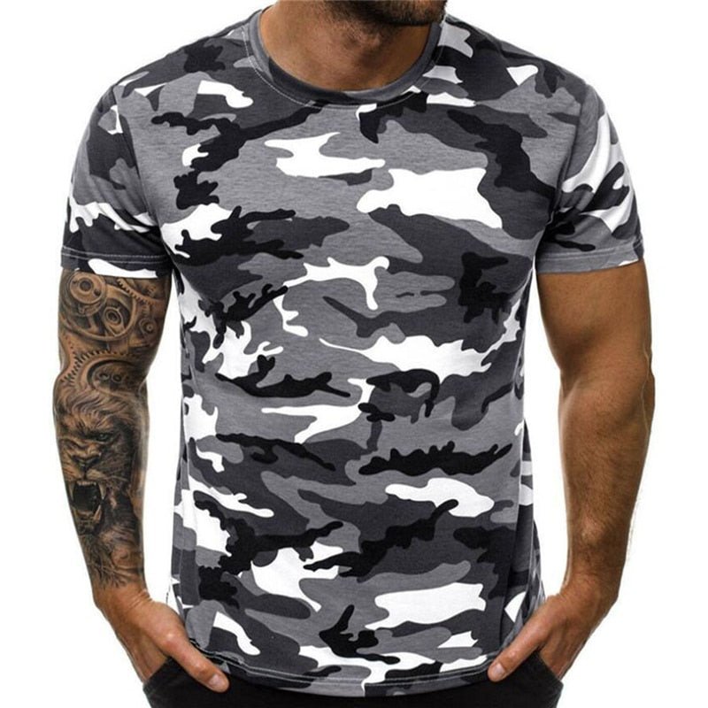 A man wearing a gray, black, and white BlasterMaster Camo T-Shirt with a tattoo on his left arm, perfect for blending in during Gel Blaster games.