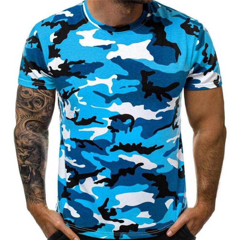 A person wearing a blue Camo T-Shirt from BlasterMaster with their hands in their pockets. The person has a tattoo sleeve on their left arm.