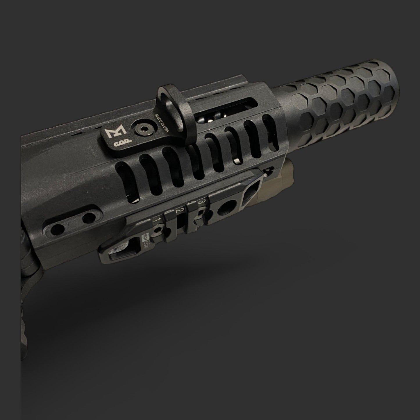 Close-up of a black CQD MLOK Forward Sling Mount by MLOCK featuring a tactical rail and hexagonal grip pattern on a dark background, showcasing its superior tactical performance and MLOK compatibility.