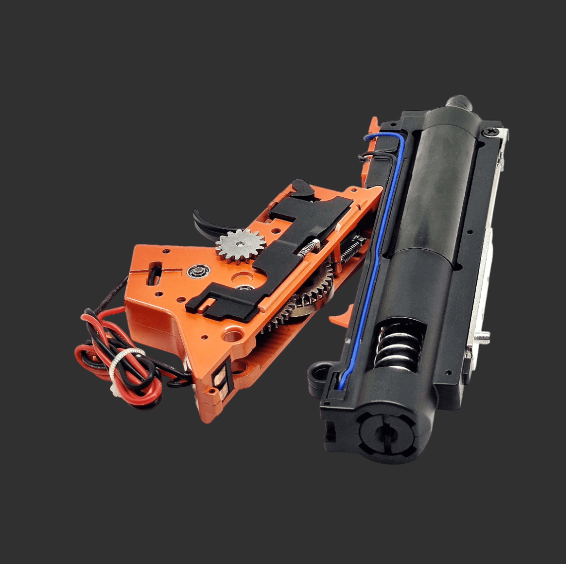 An internal gearbox mechanism for a blaster, featuring a black cylindrical component and an orange casing with visible gears and wiring, includes the Jingji GSL Metal Gearbox V2 for SR16 & HK416D by GSL for enhanced performance.