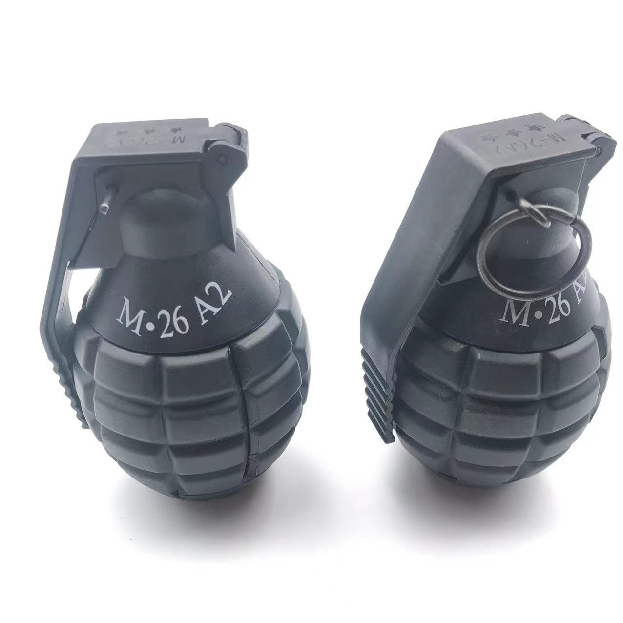 Image of two black G4 hand grenades by BlasterMaster with safety pins and levers intact, ready to unleash chaos, displayed on a white background.