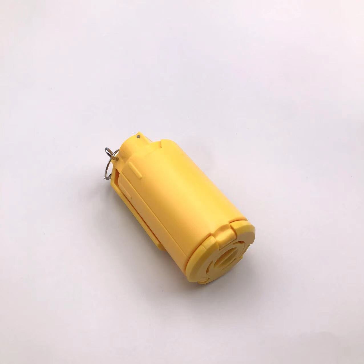 A small yellow cylindrical object with a metal ring attachment, resembling a symbol of victory, set on a plain white background. It's the G4 by BlasterMaster.