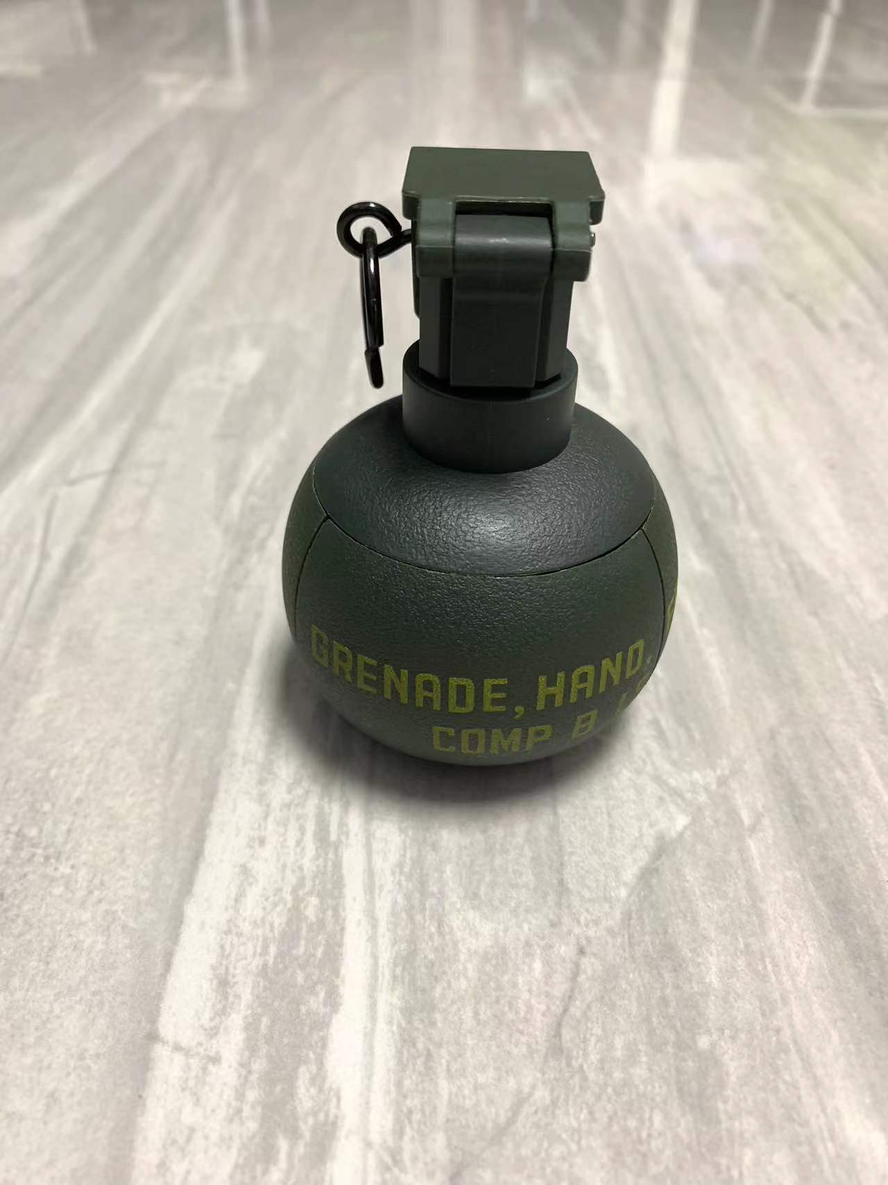 A green hand grenade labeled "G4" by BlasterMaster sits upright on a smooth, light-colored surface, ready to unleash chaos.