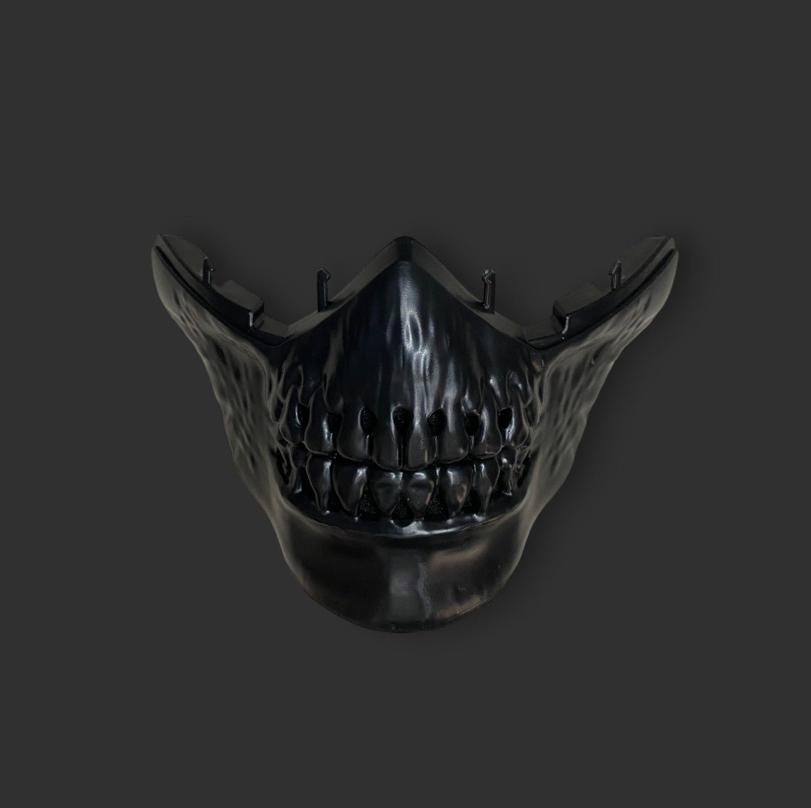 A lightweight construction, the black, menacing BlasterMasters Kids Gelsoft Mask features a jagged, tooth-like design and pointed edges on a dark background. Its adjustable design ensures a perfect fit for added comfort.