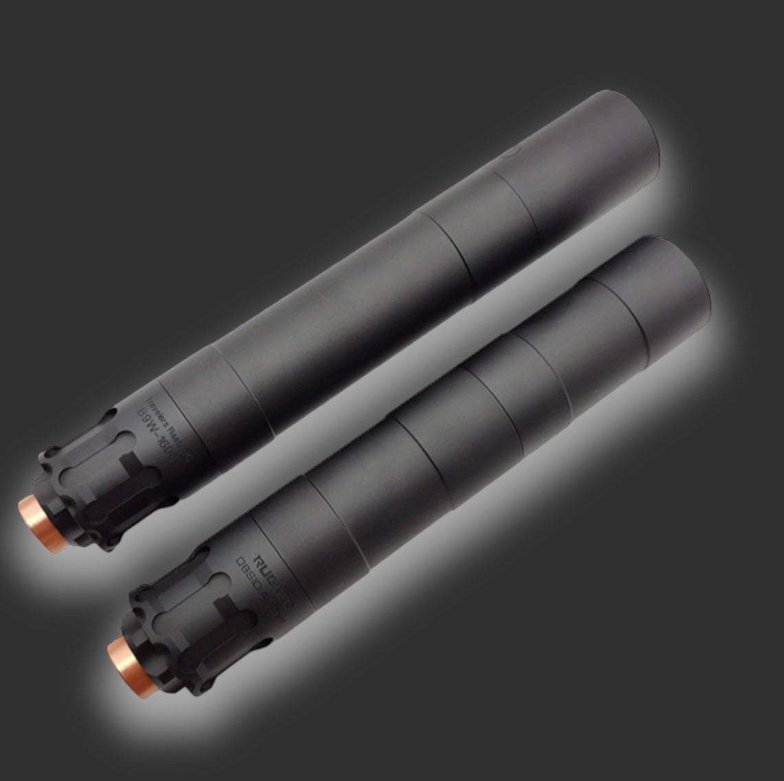 Two BlasterMasters O-9 Oppressors are displayed on a dark background. Both black cylindrical silencers feature a matte finish and metallic end caps, offering superior noise reduction for any firearm accessory.