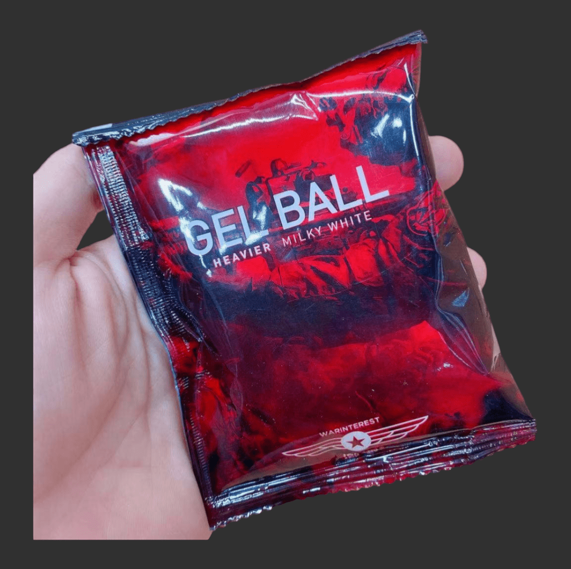 A hand holding a shiny red packet labeled "Warinterest 3.0 Red Hardened 7mm Gel Balls," perfect for gel blaster enthusiasts seeking the best 7mm gel balls from Warinterest.