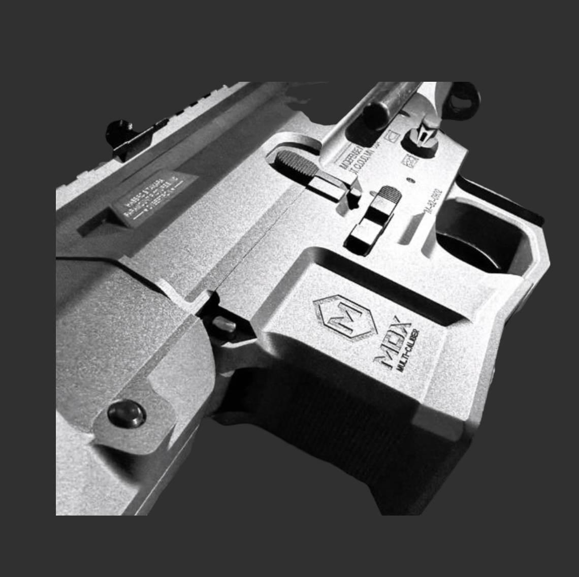 Close-up of a WD PDX Gel Blaster with engraved text and markings, showcasing part of the trigger and grip, emphasizing the metal construction. The image is in black and white.